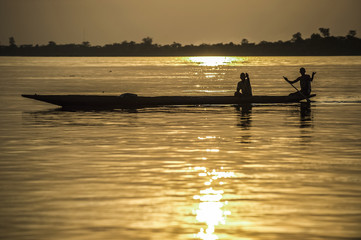 Naklejka premium Silhouette of two people in boat at sunset in Central African Republic