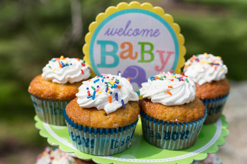 Cupcakes with white cream, glaze with powder and sprinkles for Baby shower. Waiting for baby boy