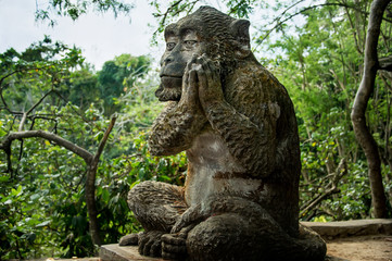 stone figure of a large monkey in a tropical forest
