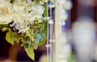 composition from white flowers as ornament on a wedding table
