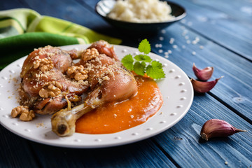 Roasted chicken thighs sprinkled with walnuts, served with apricot sauce and rice