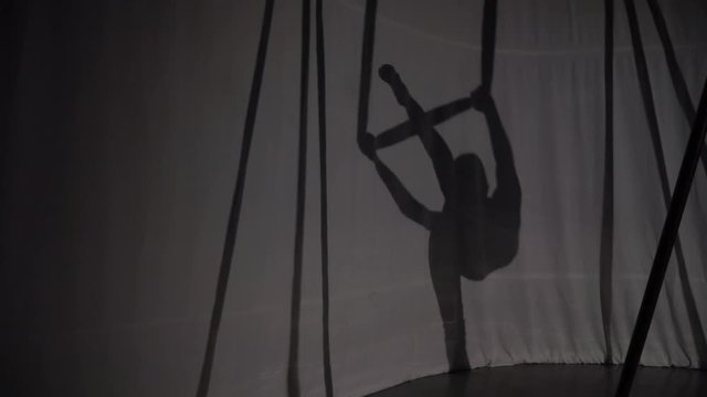 Silhouette of a girl on a hammock for yoga