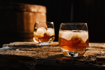 Glass of whiskey on wooden background close up