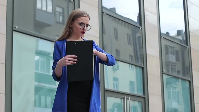 Young Business lady is waiting for a partner near an office building