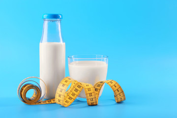 Bottle of milk with centimeter on blue background