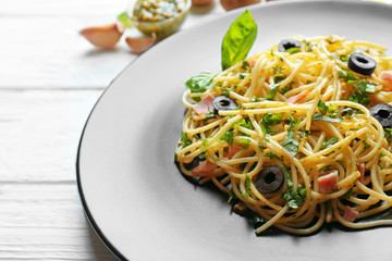 Plate with delicious pasta on wooden background