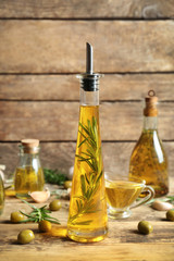 Olive oil with spices on wooden background