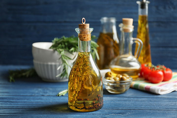 Olive oil and some spices on wooden background