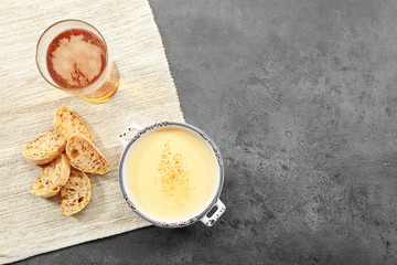 Bowl with beer cheese dip and bread slices on napkin