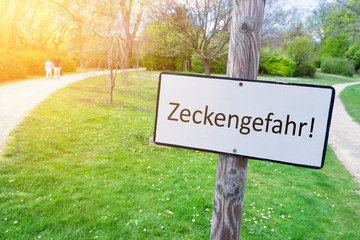 Hinweisschild Zeckengefahr in einem Park