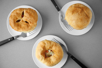 Plates with tasty chicken pot pies on grey table