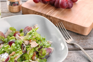 Plate with chicken salad and grapes on table