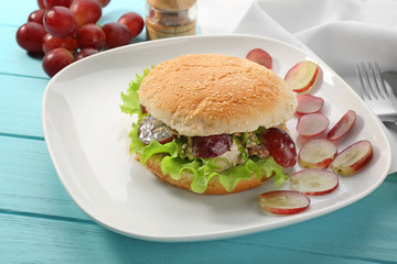 Plate with chicken salad in burger bun on  table
