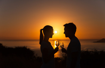 Romantic couple enjoying a glass of wine on the beach. 