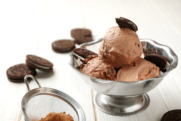 Tasty chocolate ice-cream with cookies on table