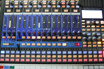 Professional audio operator working on audio mixer knobs during live TV telecast
