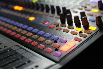 Professional audio operator working on audio mixer knobs during live TV telecast