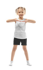 Cute girl doing gymnastic exercises on white background