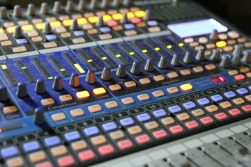 Professional audio operator working on audio mixer knobs during live TV telecast