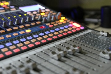 Professional audio operator working on audio mixer knobs during live TV telecast