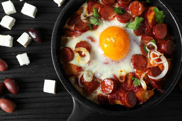 Tasty cooked egg with sausages in frying pan