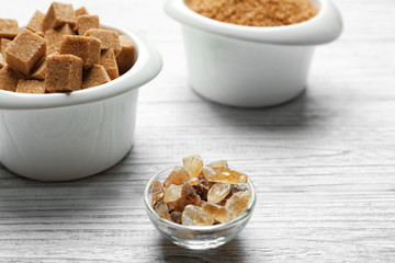 Bowls with brown sugar on wooden background