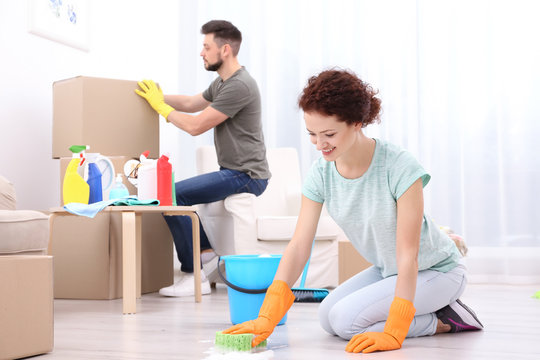 Happy Young Couple Cleaning Home Together