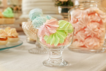 Glass bowl with merengues on table with different sweets