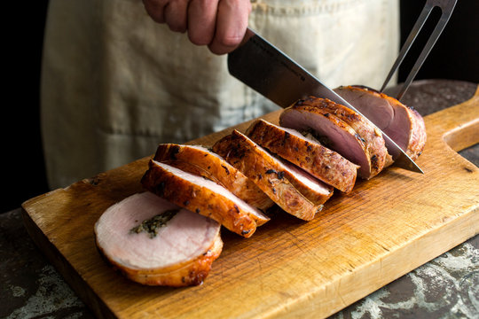 Man Cutting Herb Stuffed Pork Tenderloin 