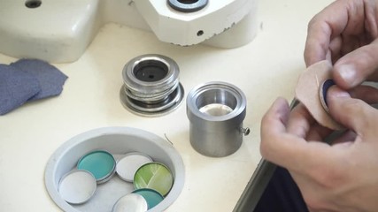 Man's hands making buttons on the factory