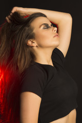 Naklejka premium Perfect brunette woman with art makeup at studio with red light