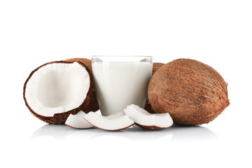 Glass of coconut milk with nuts on white background