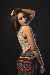 Attractive young woman with dark makeup and blue studio light