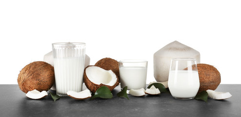 Glasses of coconut milk with nuts on white background