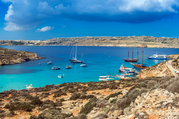 Comino, Malta - Panoramic skyline view of the  beautiful Blue Lagoon on the island of Comino with sailboats, traditional Luzzu boats and tourists enjoying the mediterranean sea
