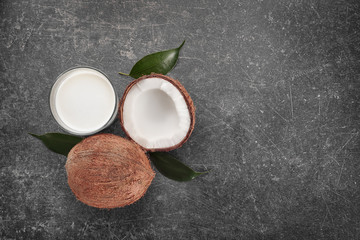 Obraz na płótnie Canvas Glass of coconut milk with nuts on gray background