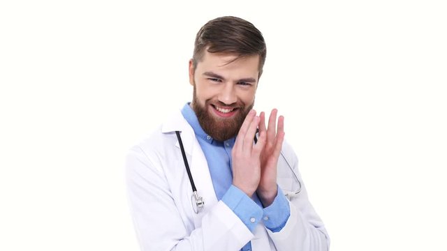 Wily young doctor wearing white lab coat fingering over and smiling isolated