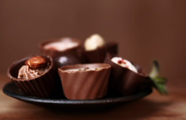 Plate with delicious chocolate  candies, closeup
