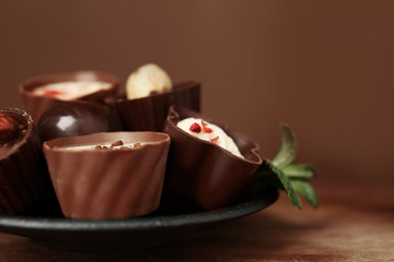 Plate with delicious chocolate  candies, closeup