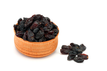 Organic dried Raisins in wood plate isolated on white background