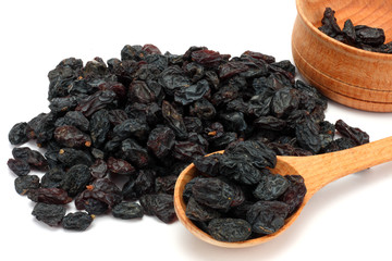 Organic dried Raisins in wood plate isolated on white background