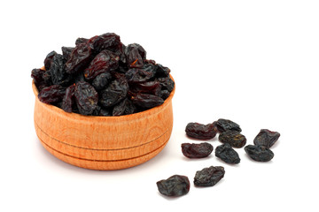 Organic dried Raisins in wood plate isolated on white background