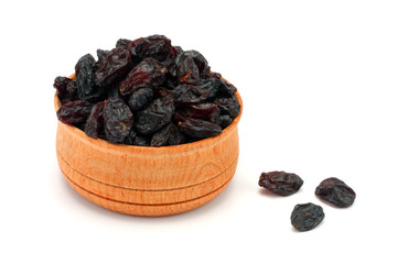 Organic dried Raisins in wood plate isolated on white background
