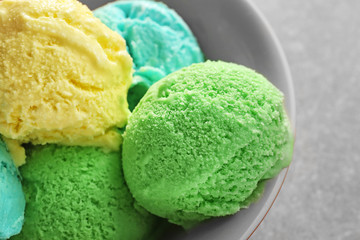 Bowl with different tasty ice cream  on gray background