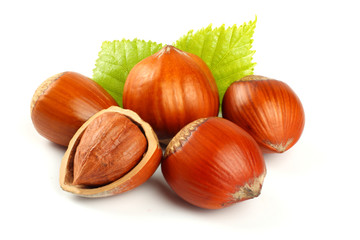 hazelnuts with green leaf isolated on white background