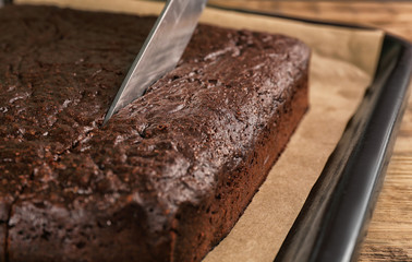 Cutting of delicious chocolate brownie on baking tray