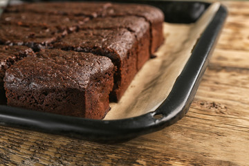 Baking tray with delicious chocolate cake on wooden table