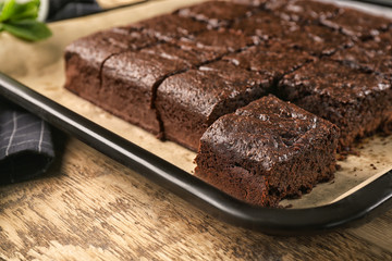 Fototapeta na wymiar Baking tray with delicious chocolate cake on wooden table
