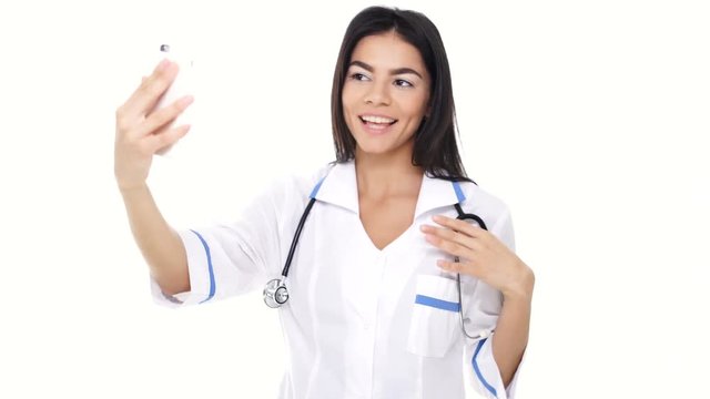 Woman nurse smiling and making selfie using sartphone isolated