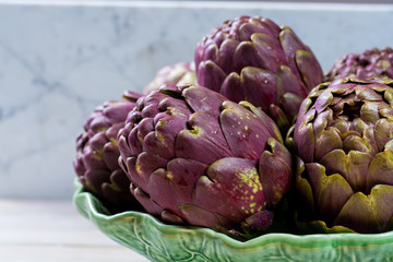 Obraz premium Fresh big Romanesco artichokes green-purple flower heads ready to cook